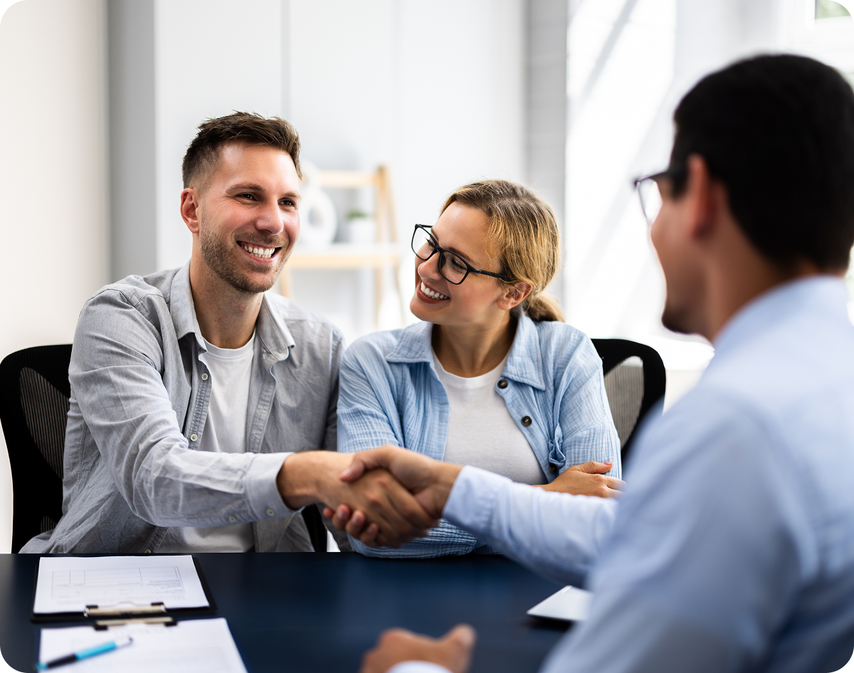 Couple shaking hands with a businessman.
