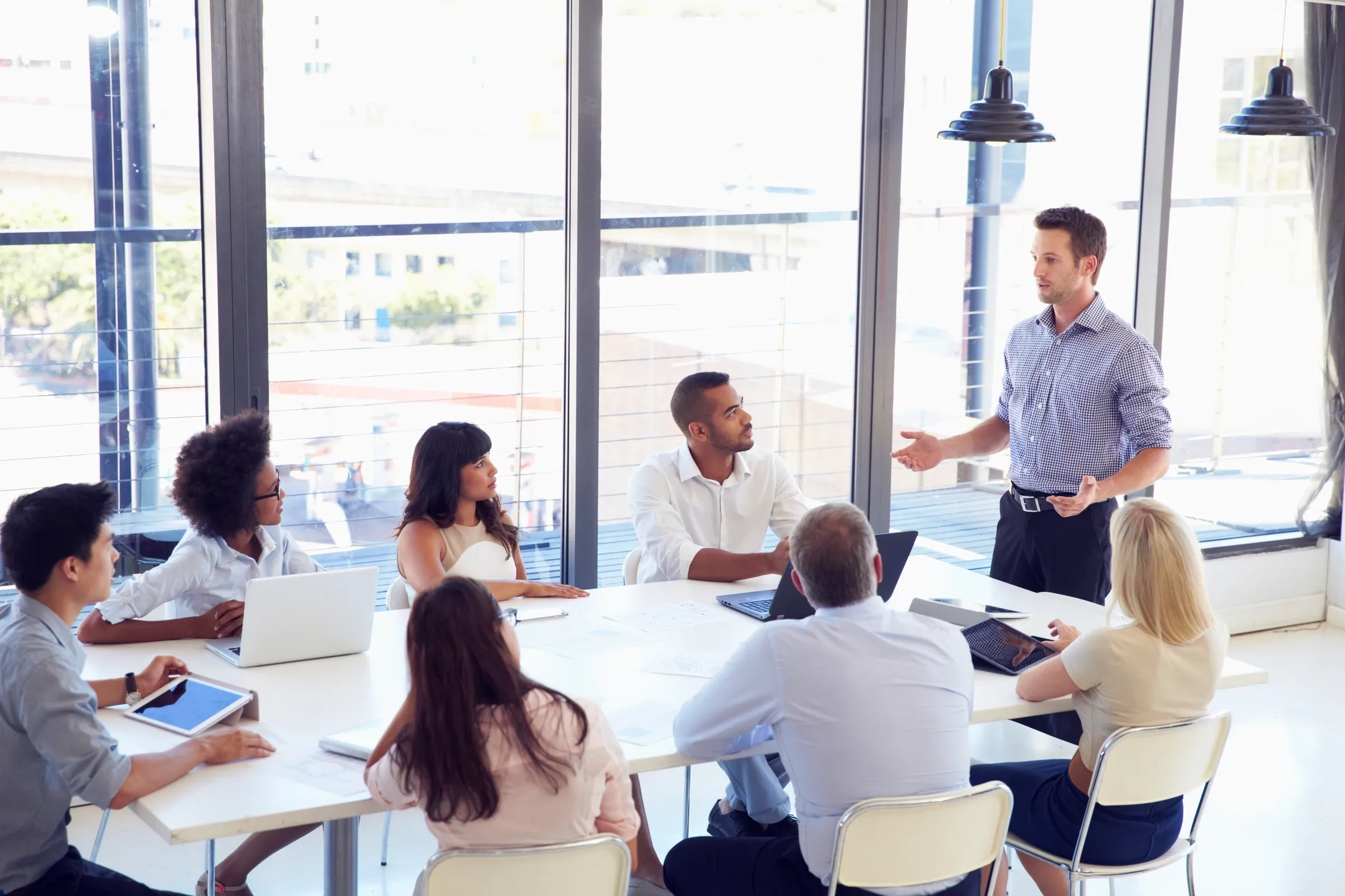 A business meeting with a presenter and attentive team around a table.