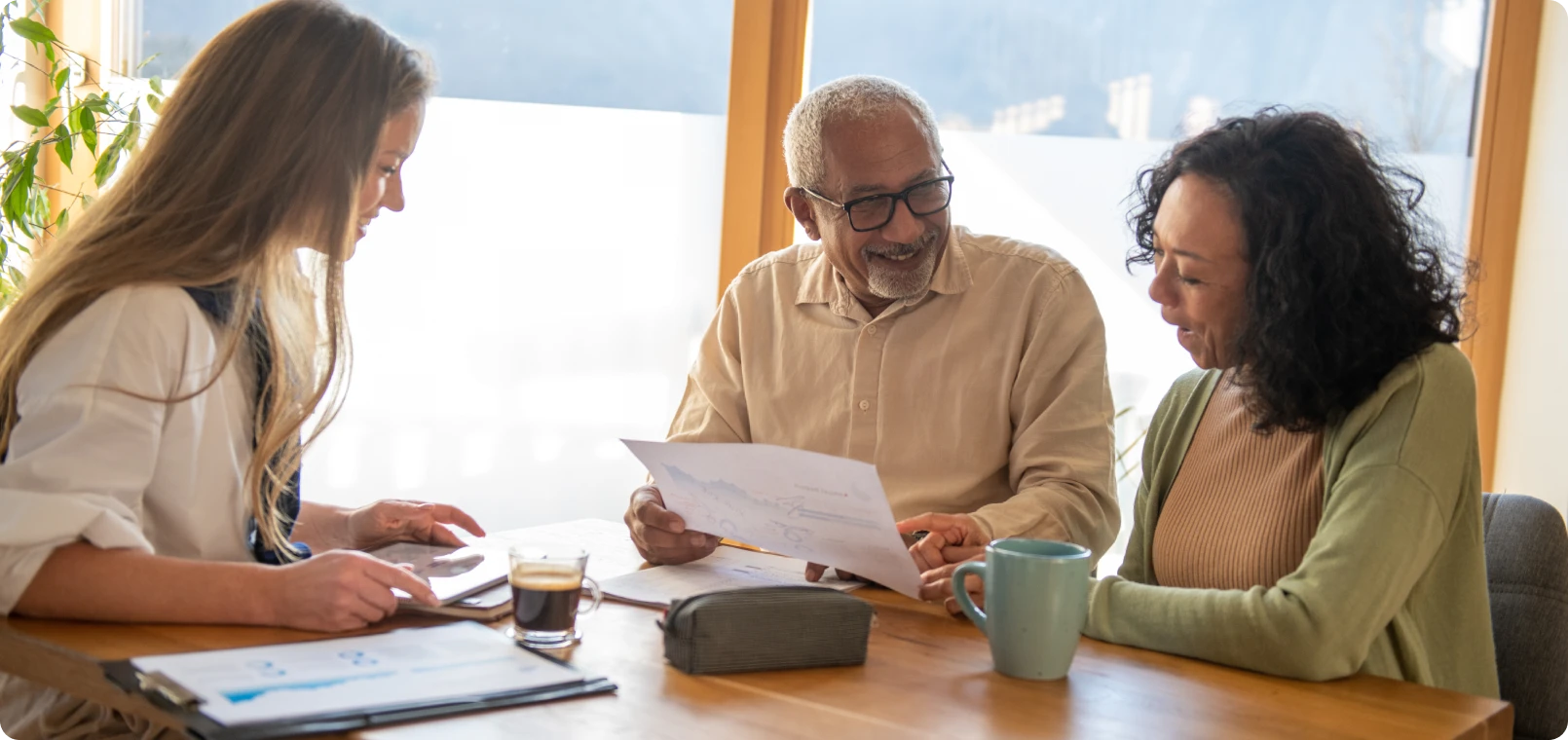 Three people reviewing documents at table.